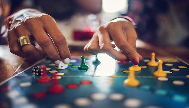 Close-up of two hands moving pawns on a board game
