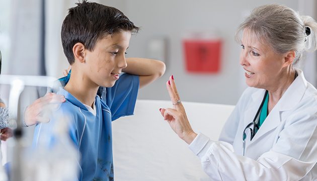 Young soccer player and female physician during exam for concussion