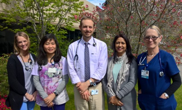 PeaceHealth staff pose for a group photo in front of trees