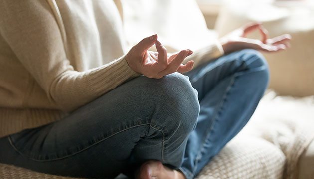 woman meditating on couch