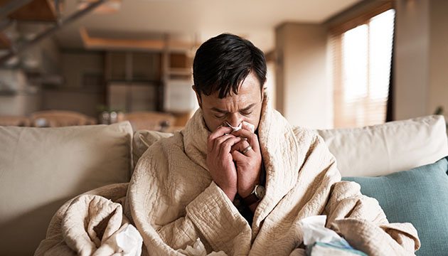 Person sneezes into tissue