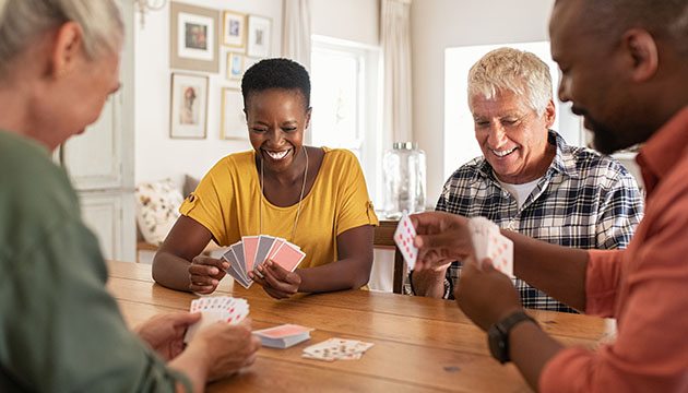 Four people happily playing a card game