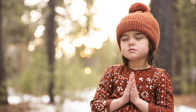 young girl outside praying