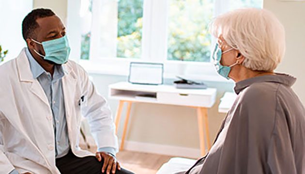 Doctor talks with a woman patient in exam room