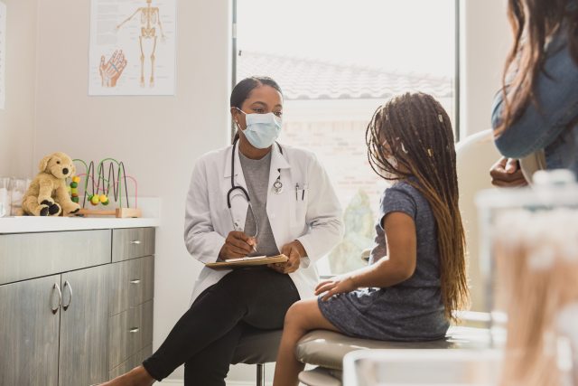 Young girl and her mother visit with a pediatrician