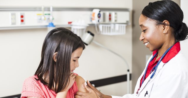 Young girl getting vaccine from doctor