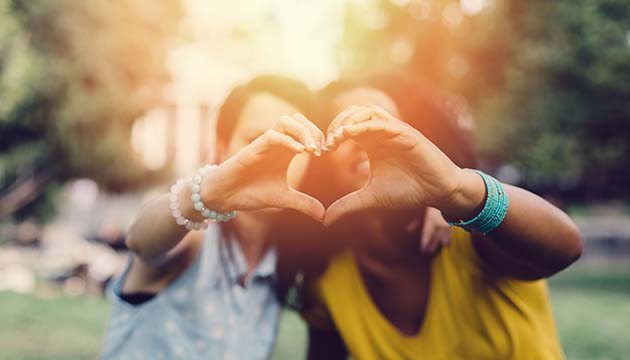 women making a heart with hands