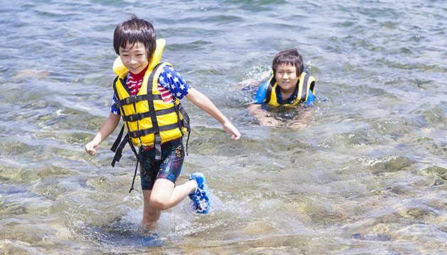 Two young boys swimming in a lake