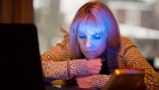 woman using SAD light and computer