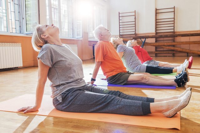 group of people stretching and conditioning on the floor