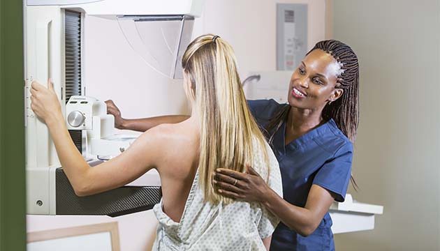 mammography technician helps young woman get mammogram