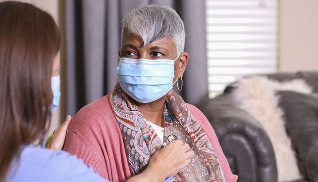 Healthcare worker listens to a woman's heart