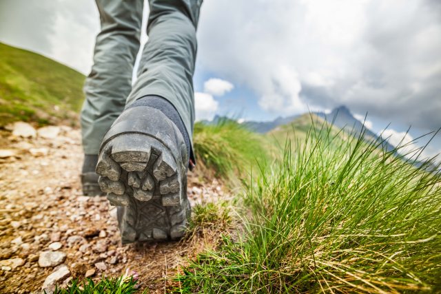 Boots hiking up a mountain trail
