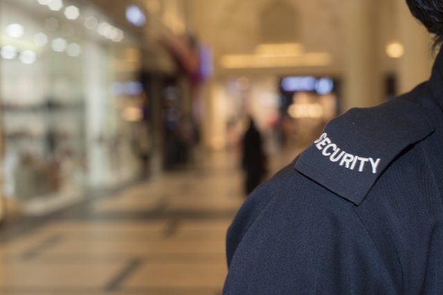 Close-up of security guard's shoulder with the word "security" on a patch