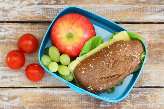 Balanced lunch with sandwich, apple, grapes and tomatoes