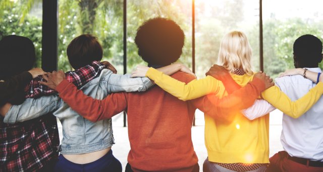 A group of people with their backs to the camera embracing