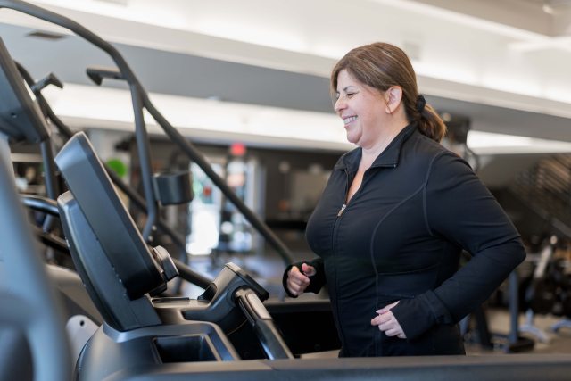 A woman smiling while exercising in the gym