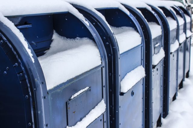 A row of snow covered postal boxes