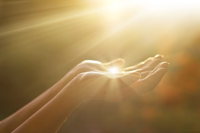 Hands in a bowl shape catching sunlight
