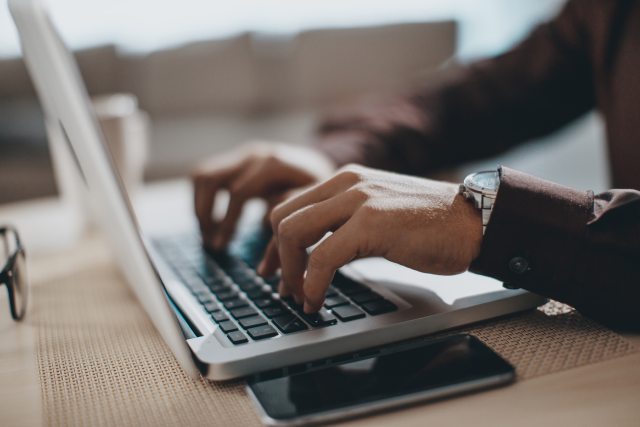 A person types on a laptop