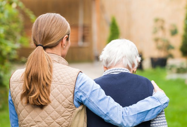 A younger woman with her arm wrapped around an older woman