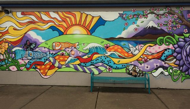 Colorful mural with animals and other scenes of nature on the wall of a school