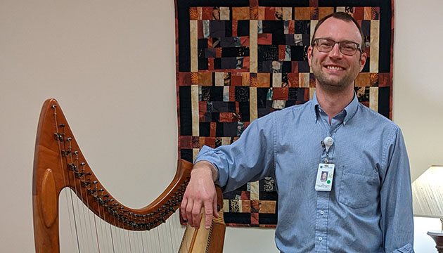 Kieran Schnabel stands near his harp