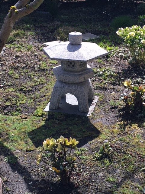 A stone statue of a structure in a garden