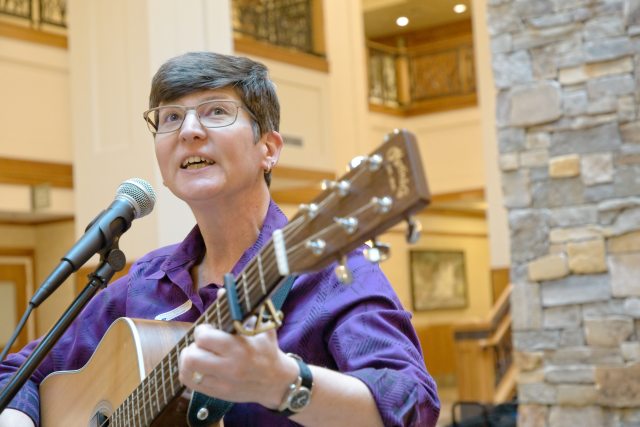 Micki Varner, PeaceHealth Oregon interim director of Mission Services, plays guitar and leads caregivers in song at PeaceHealth Sacred Heart Medical Center at RiverBend in Springfield, Ore.