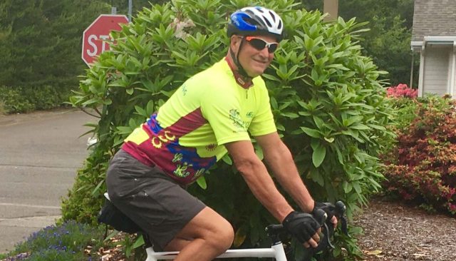 Orthopedic patient Warren Youell riding a bicycle through a neighborhood