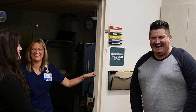 Wound Center staff and John share a laugh outside hyperbaric room