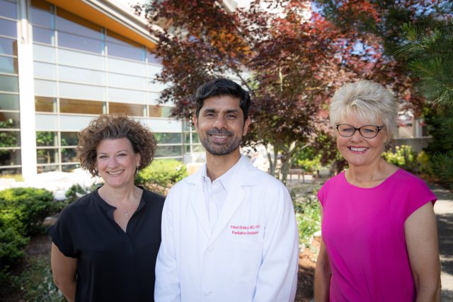 Three PeaceHealth cancer center caregivers pose outside of hospital