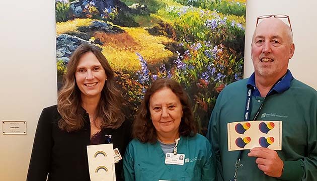 PeaceHealth pharmacy team members hold rainbow stickers 