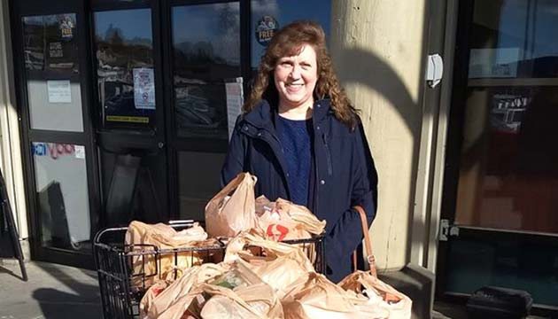 Shellie Saddoris pauses with full grocery cart for Ketchikan's shelter pantry