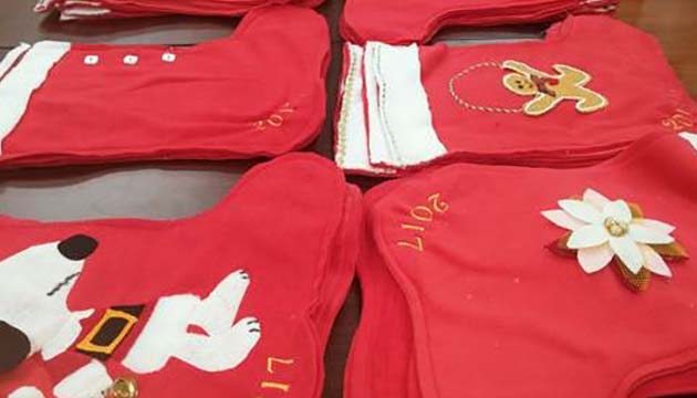 Red holiday stockings adorned with Christmas themed decorations and the year 2017 stitched in the sides